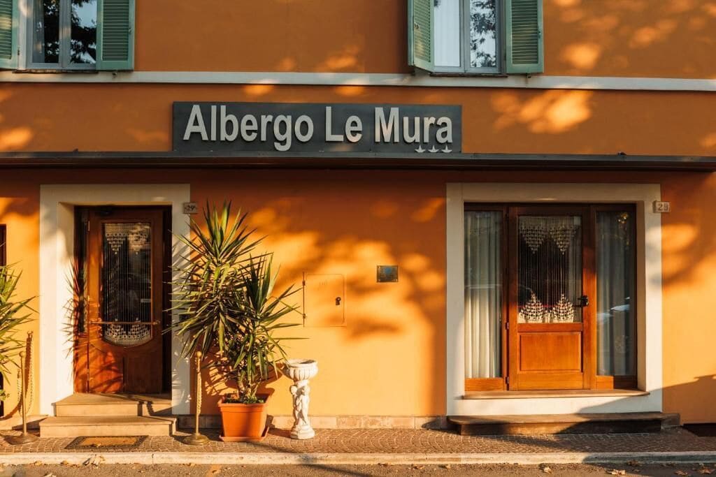 Un edificio con un cartello che riporta la scritta 'Albergo Le Mura'.
