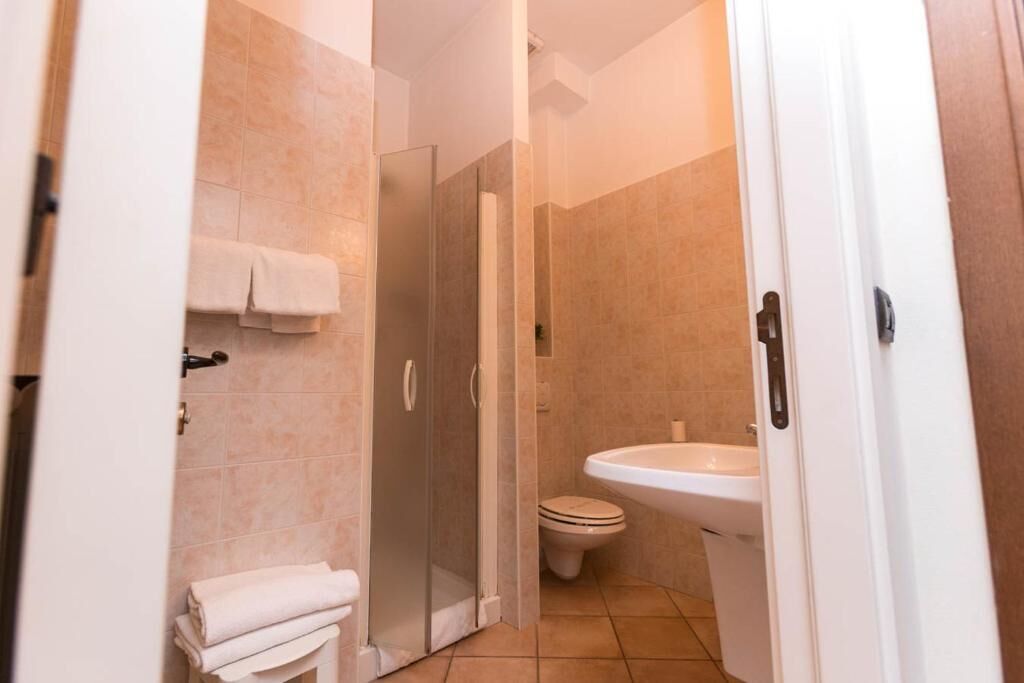 A bathroom with a shower, toilet, and sink.