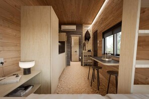 Eine kleine, moderne Küche mit Holzwänden, einem eingebauten Spülbecken und einem Fenster, das für natürliches Licht sorgt.