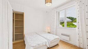 A bedroom with a bed, a bedside table, a window with a view, and a wardrobe. - Beach 100m away, apartment with terrace for 4 (Longeville-sur-Mer)