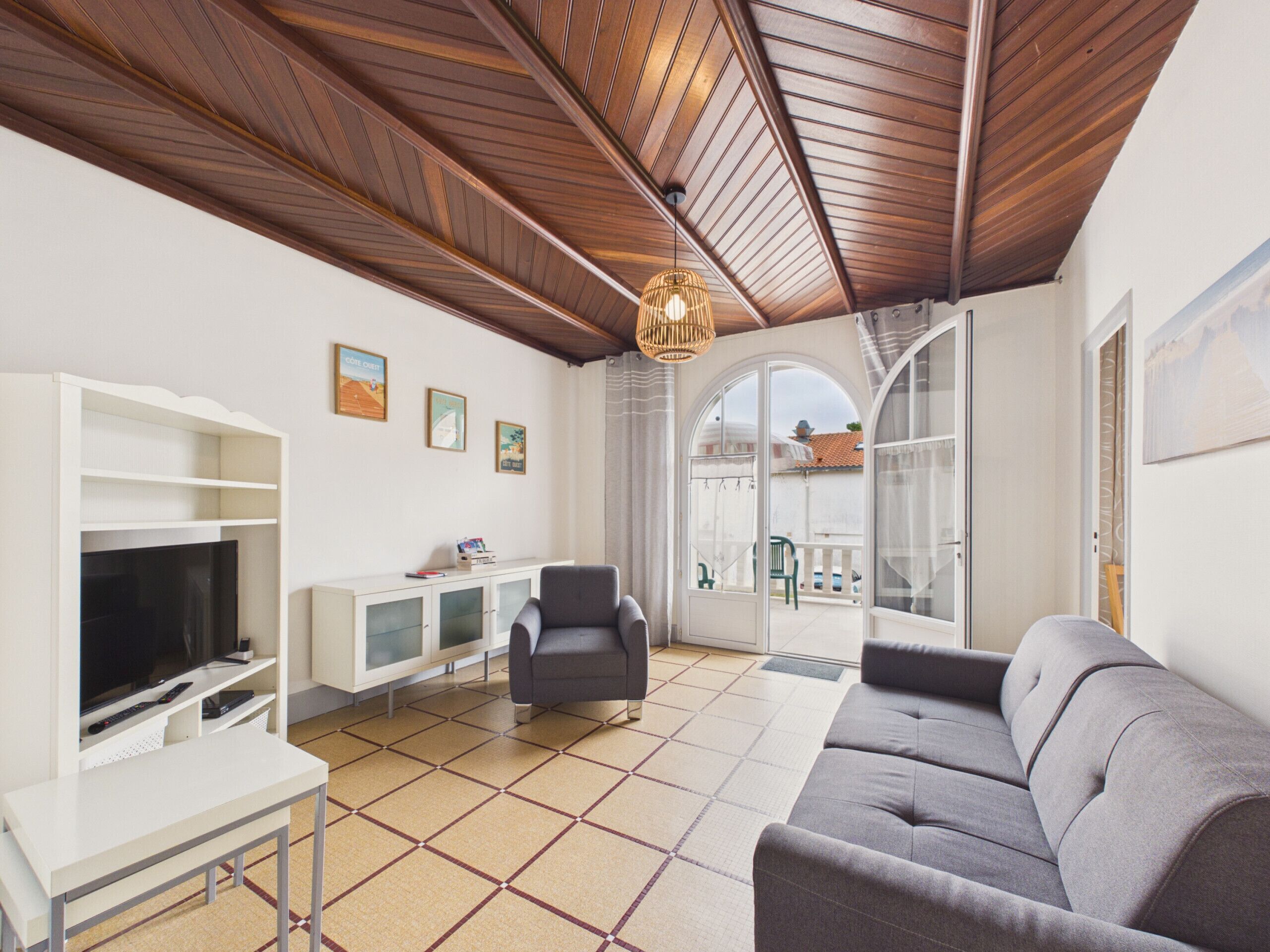 A living room with a television, sofa, and a white cabinet.