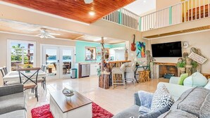 A spacious living area with a kitchen, dining area, and a balcony with a view. - Lakeside House | Waterfront escape in Austin with resort-style pool (Austin)