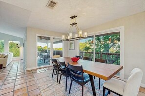 A dining area with a wooden table, chairs, and a chandelier. - Peaceful retreat on Lake Travis with amazing views near wineries & distilleries (Lakeway)