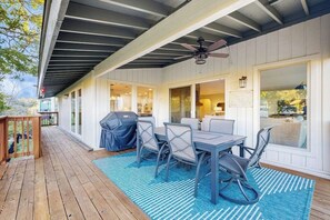 A covered patio with a table and chairs, a ceiling fan, and a view of the outdoors. - Peaceful retreat on Lake Travis with amazing views near wineries & distilleries (Lakeway)