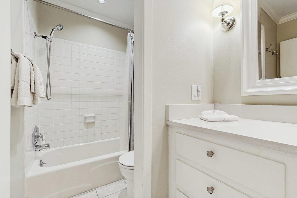 Une salle de bain avec une baignoire, des toilettes et un meuble-lavabo avec des tiroirs.