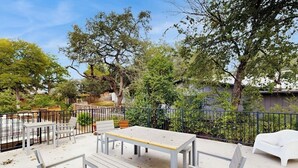 An outdoor patio with white furniture, a table, and a chair. - Charming, dog-friendly townhouse w/private gas grill, patio, & near downtown (Austin)