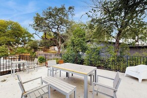 Eine Terrassengruppe mit weißen Möbeln, einem Tisch und einem Stuhl.