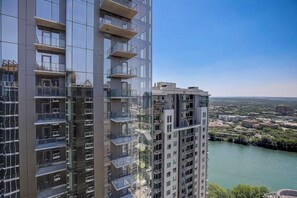 A high-rise building with multiple balconies, a river view, and a clear sky. - Penthouse with river view balcony, rooftop pool & prime location, dog-friendly (Austin)