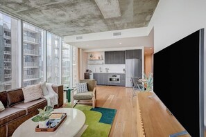 Ein modernes Wohnzimmer mit einer Couch, einem Couchtisch und einem Fernseher.