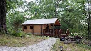 A rustic cabin with a gravel path leading to it, surrounded by trees. - Great Small Group Safari Tent in Livingston, Texas (Livingston)