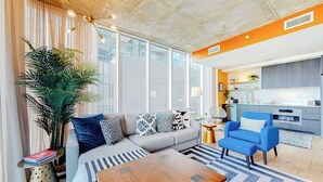 Una sala de estar moderna con un sofá, una mesa de centro y un sillón azul.