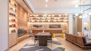 Un interior moderno con una estantería de madera, una mesa de comedor y zonas de estar.