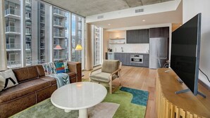 Un apartamento moderno con sala de estar, cocina y ventanas amplias.