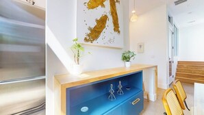 A modern interior with a wooden console table, a blue cabinet, and a large abstract painting. - Modern two story home with kitchen, gated yard, balcony, close to South Congress (Austin)
