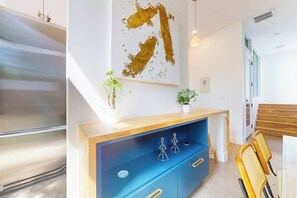 A modern interior with a wooden console table, a blue cabinet, and a large abstract painting. - Modern two story home with kitchen, gated yard, balcony, close to South Congress (Austin)