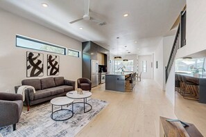 A spacious living area with a sofa, coffee table, and artwork on the wall. - Two modern townhouses with enclosed backyards (Austin)