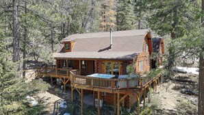 Una cabaña con terraza, jacuzzi y chimenea.