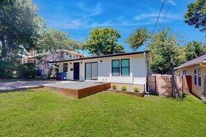 A modern single-story house with a front porch, a small front yard, and a wooden fence. - UT + Downtown 2BR | Sleeps 6 + Free Parking (Austin)