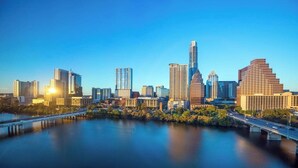 A city skyline with modern high-rise buildings, a river, and a bridge. - Lovely Austin condo close to downtown with streaming, W/D, central AC, & WiFi (Austin)