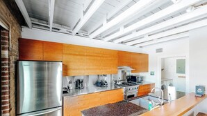 Una cocina moderna con electrodomésticos de acero inoxidable, armarios de madera y una isla central con pileta.