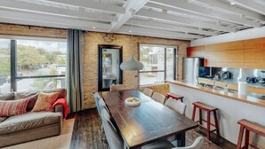 Un interior moderno con comedor, cocina y ventanas amplias.