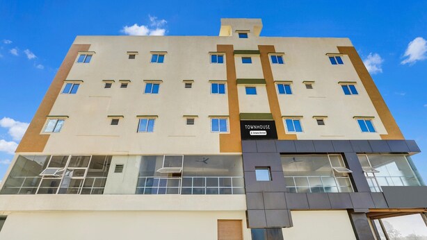 A multi-story building with a sign reading 'TOWNHOUSE & Company Services.' - Deluxehennur Prakruthi Layout Bangalore (Bengaluru)