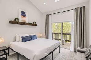 A bedroom with a bed, a nightstand, a bedside table, a window with curtains, a wooden deck outside, and a wall-mounted shelf with decorative items. - Stop in for the 3br/2ba Ultimate Mountain Lifestyle! (Frisco)