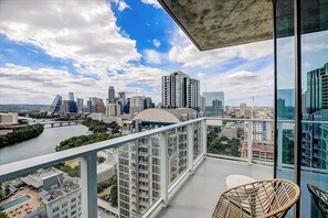 Ein Balkon mit Blick auf die Stadt, darunter ein Fluss und moderne Gebäude.