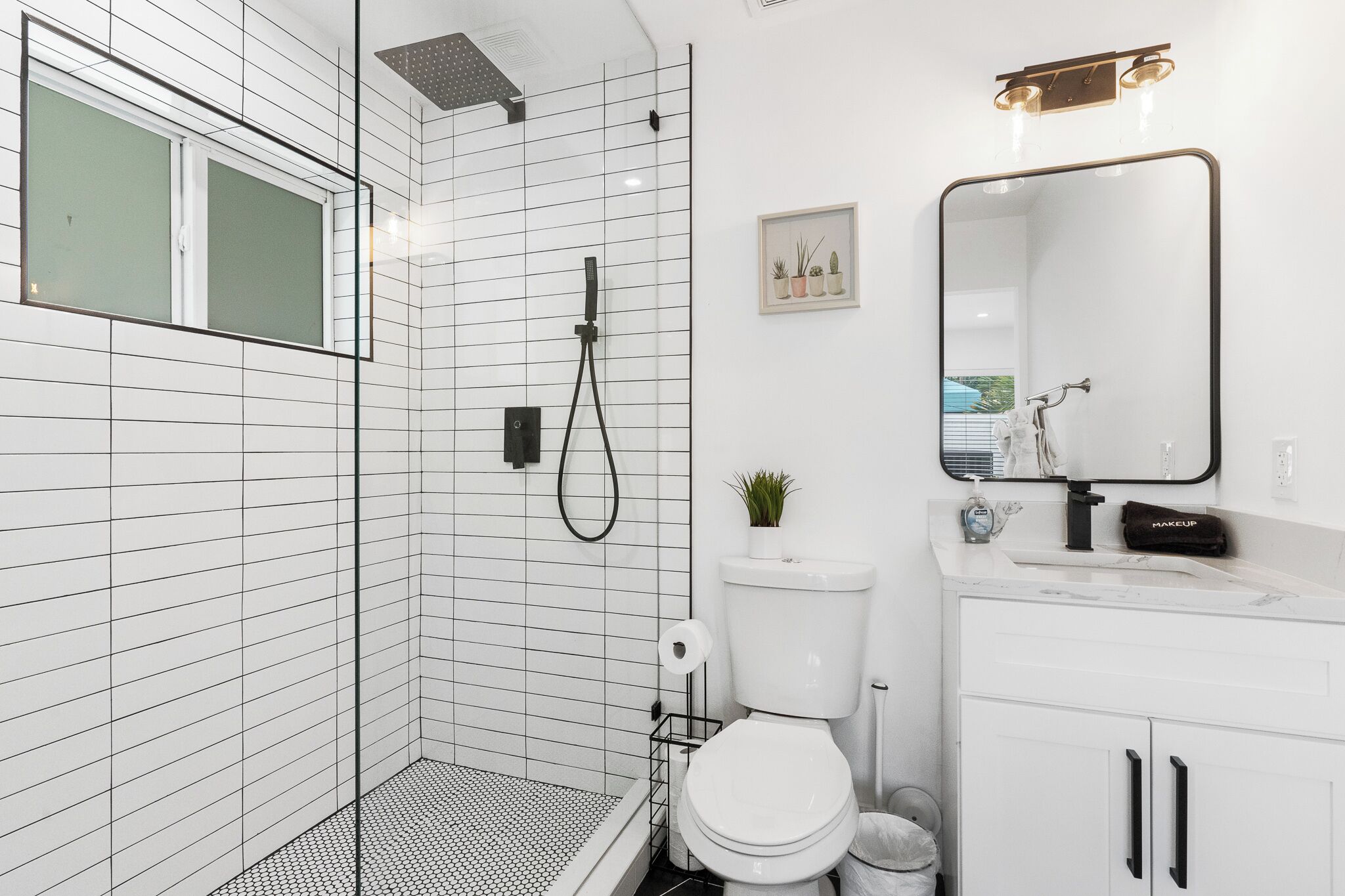 A modern bathroom with a shower, toilet, and sink.