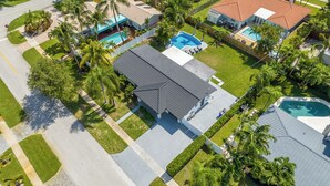 Et boligområde med flere huse, en swimmingpool og en velplejet græsplæne.
