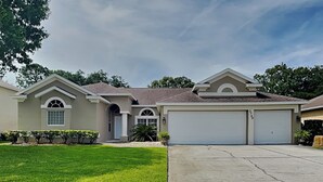 A residential house with a garage, a well-maintained lawn, and a clear sky. - Sunrise Paradise (Port Orange)