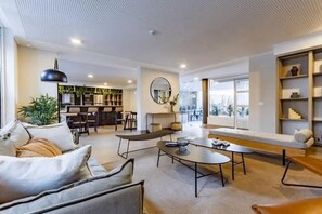 Ein modernes Wohnzimmer mit einer Couch, einem Couchtisch und einem Essbereich mit Stühlen und einem Tisch.