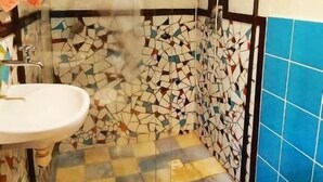 A bathroom with a shower, a sink, and a toilet. - Sítio Salamandra (Aiuruoca)