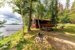 A cabin with a dock, surrounded by trees, near a lake. - Secluded Pet-Friendly Cabin Rental on Big Lake for Dreamy Glamping in Ely, MN (Ely)