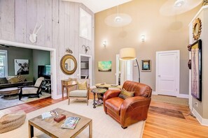 A living room with a sofa, coffee table, and a fireplace. - Quiet central home with enclosed yard, deck, grill, central AC, & washer/dryer (Austin)