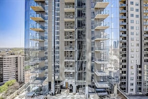 A modern high-rise building with multiple balconies, large windows, and a clear view of the surrounding area. - Downtown Austin Luxe condo w/private balcony - rooftop pool & gym (Austin)