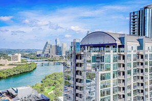 Ein modernes Hochhaus mit Glasfassade, einer Kuppel auf dem Dach und einem Fluss im Hintergrund.