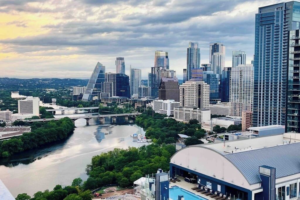 A cityscape with modern high-rise buildings, a river, and a bridge.