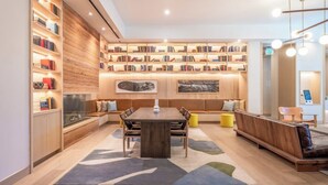 Eine moderne Bibliothek mit Bücherregalen, einer Essecke und Sitzgelegenheiten.