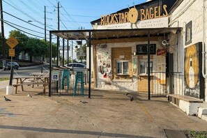 Ein Gebäude mit einem Schild, auf dem 'Rockstar Bagels' steht, und einem überdachten Außenbereich mit Sitzgelegenheiten.