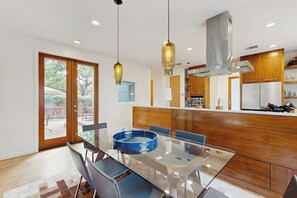 A modern kitchen with wooden cabinets, a central island, and pendant lighting. - Stunning dog-friendly house w/private gas grill & deck -steps to South Congress (Austin)
