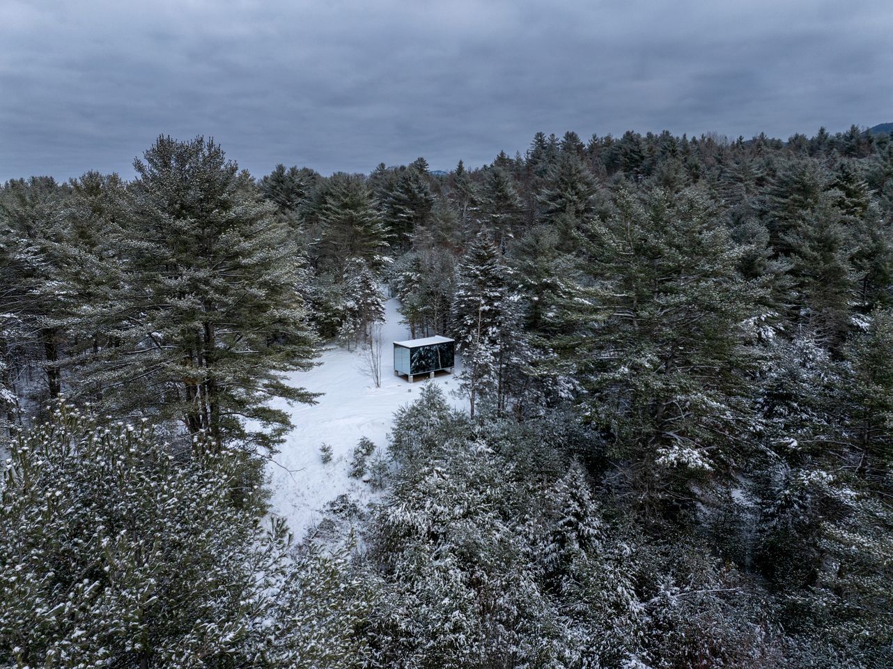 A cabin surrounded by snow-covered trees.