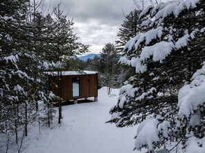 Una cabaña de madera rodeada de árboles cubiertos de nieve.