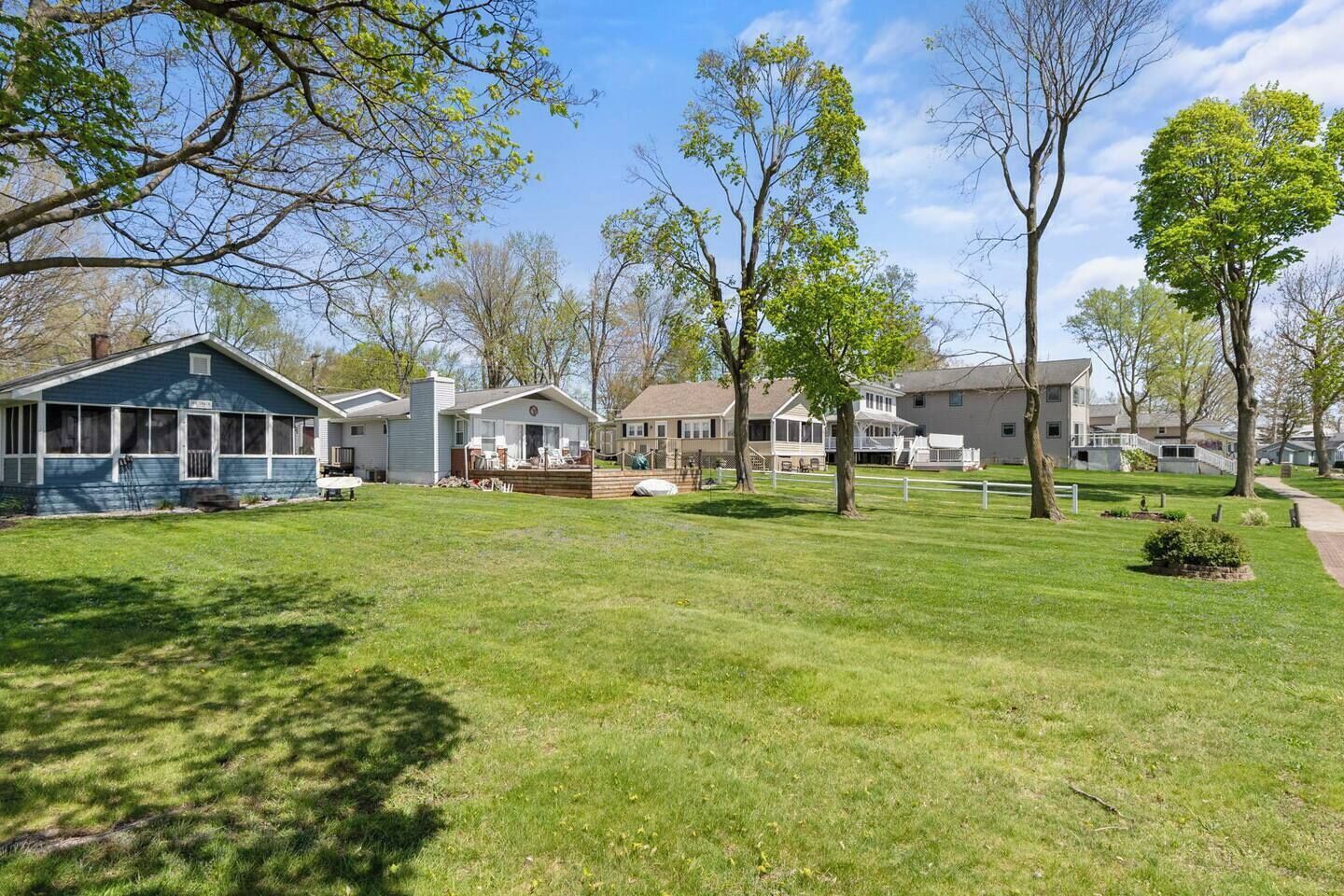 A residential area with houses, a well-maintained lawn, and trees.