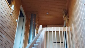 Un escalier en bois avec une rampe, un ventilateur de plafond et une vue sur la pièce située en contrebas.