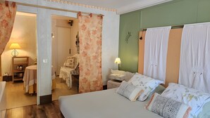 Une chambre à coucher comprenant un lit, une table de chevet, une lampe, une chaise et une porte donnant sur une autre pièce.