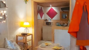 Une pièce avec une table en bois, une lampe, un miroir et une figurine décorative.