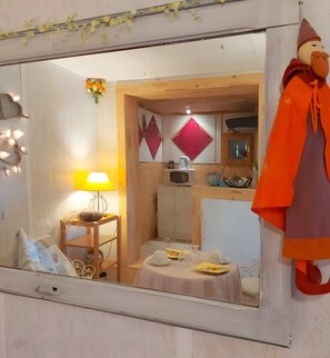 Ein Zimmer mit einem Holztisch, einer Lampe, einem Spiegel und einer Dekofigur.
