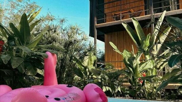 Uma piscina com um flamingo inflável rosa.