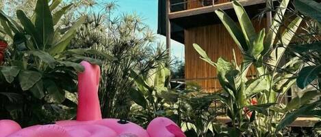 A swimming pool with a pink inflatable flamingo float.